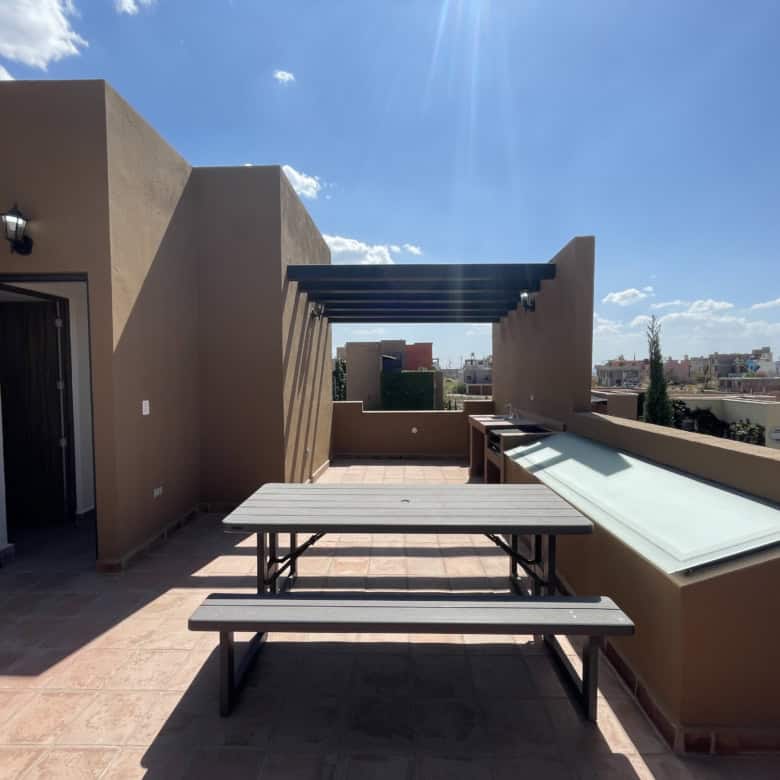 Stylish rooftop terrace with cityscape views, outdoor dining area, and sun protection.