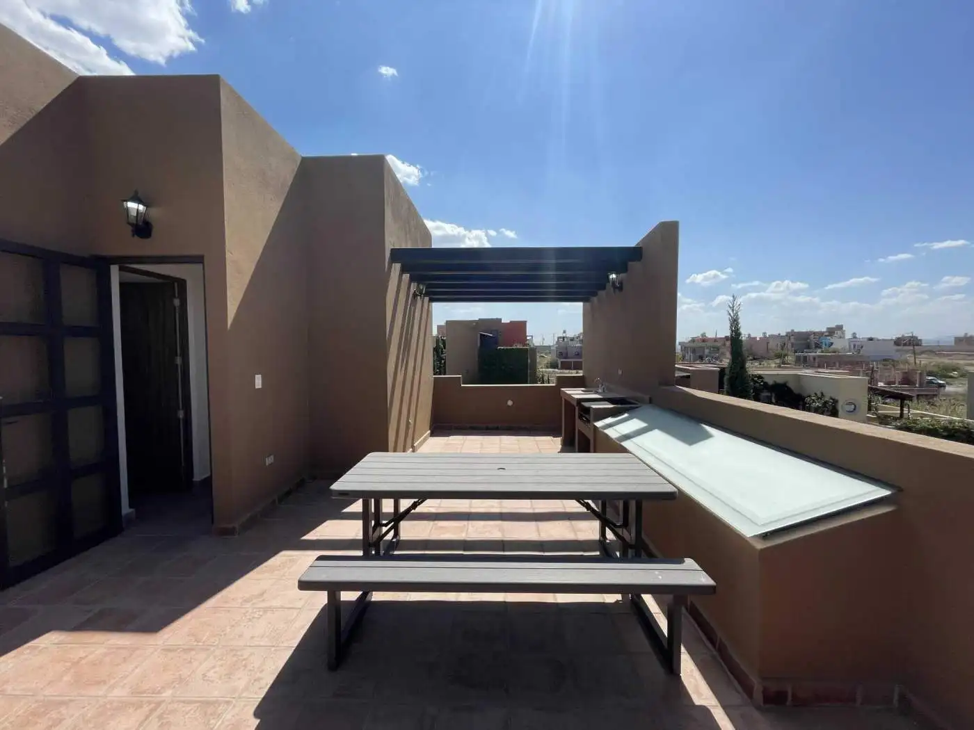 Stylish rooftop terrace with cityscape views, outdoor dining area, and sun protection.