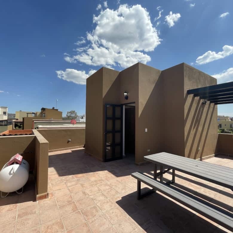 Rooftop terrace featuring outdoor seating, city skyline views, and a clear blue sky. Perfect for rel.