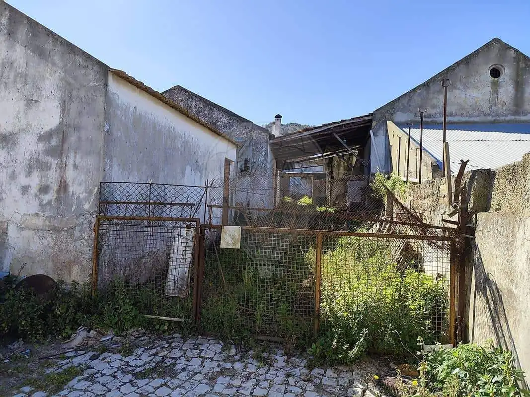 Empty plot of land enclosed by a rusty fence in Cabanas Setubal Portugal, suitable for building or d.