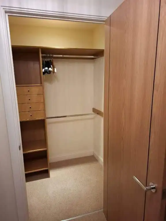 In closet with wooden shelves and hanging space in a modern apartment.