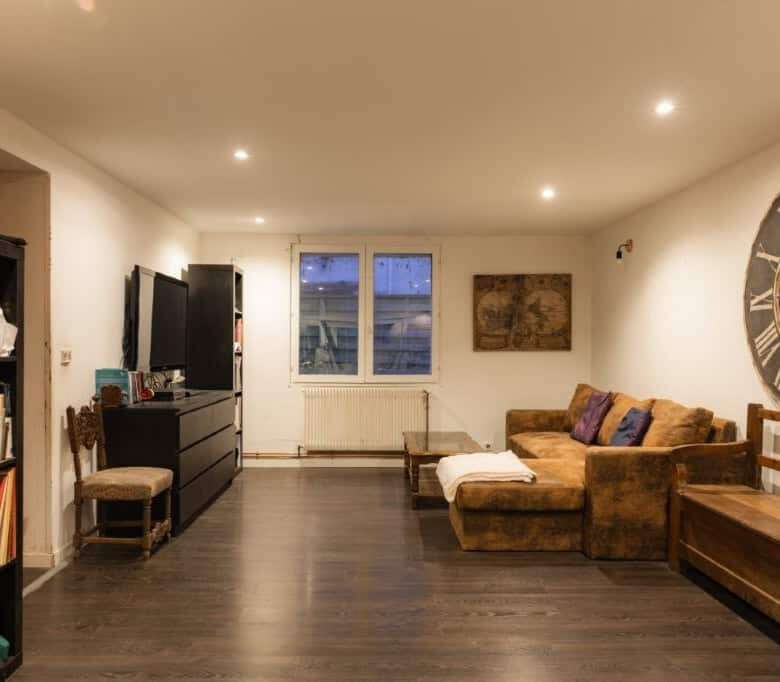 Spacious living area featuring a cozy sofa, bookshelves, and stylish decor.