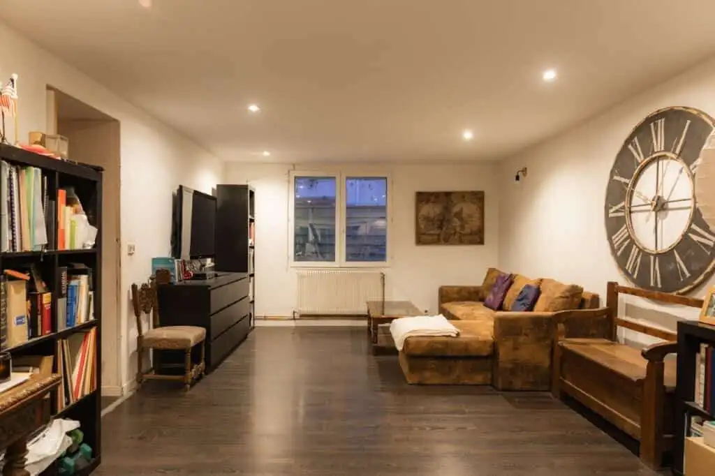 Spacious living area featuring a cozy sofa, bookshelves, and stylish decor.