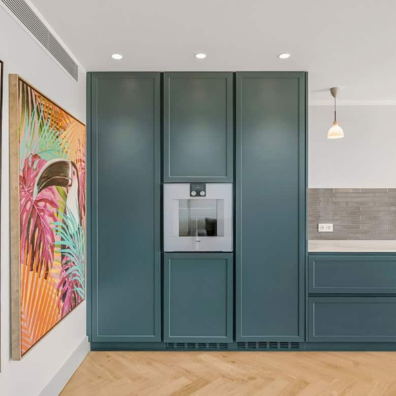 Stylish blue kitchen cabinetry with integrated appliances and vibrant animal art.