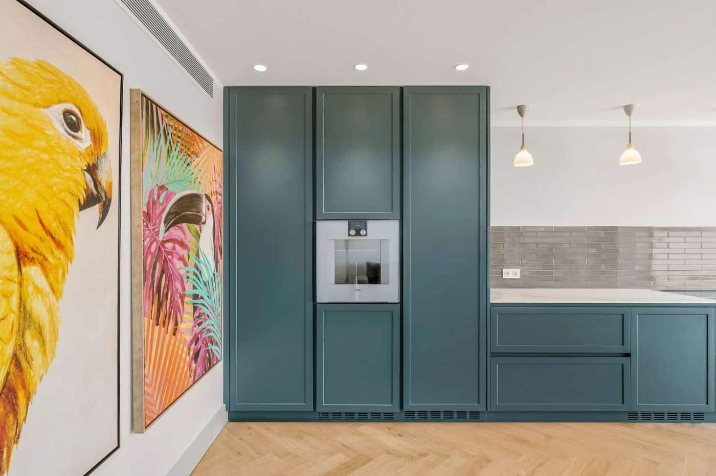 Stylish blue kitchen cabinetry with integrated appliances and vibrant animal art.