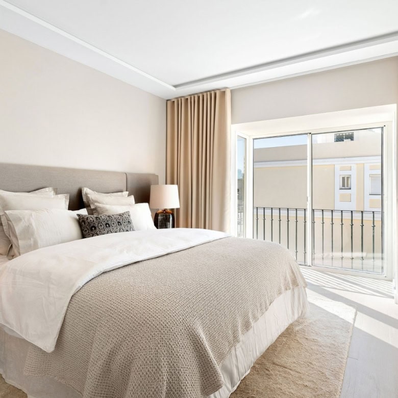 Bright bedroom with panoramic city views from the duplex penthouse balcony.