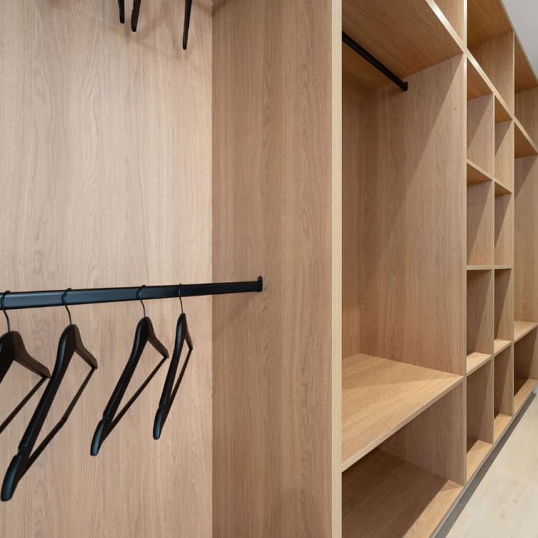 Luxurious walk-in closet with wooden shelves and hanging space in a panoramic duplex penthouse.