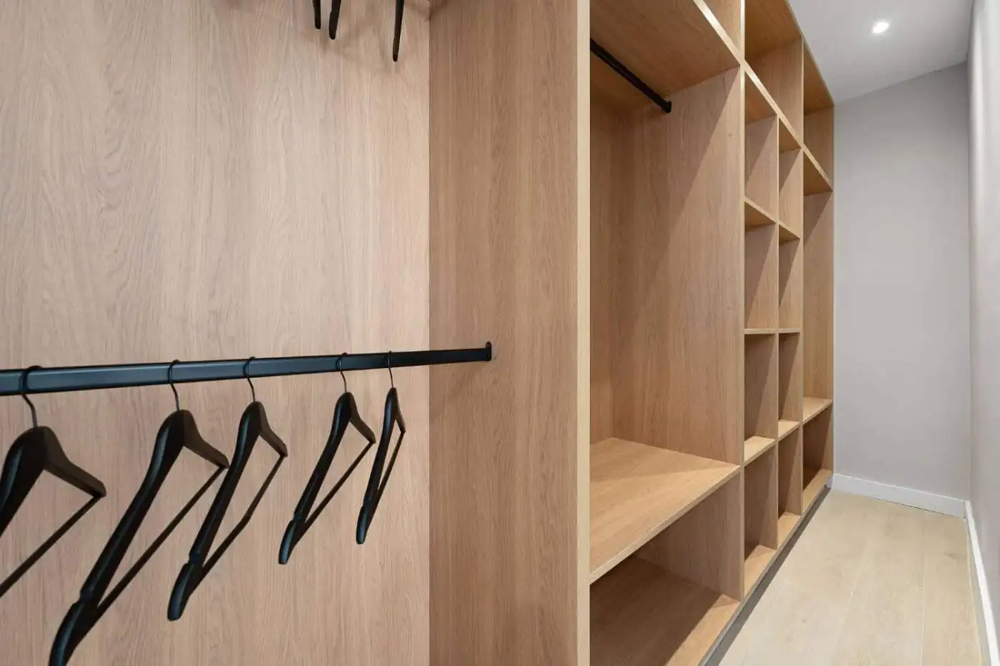 Luxurious walk-in closet with wooden shelves and hanging space in a panoramic duplex penthouse.