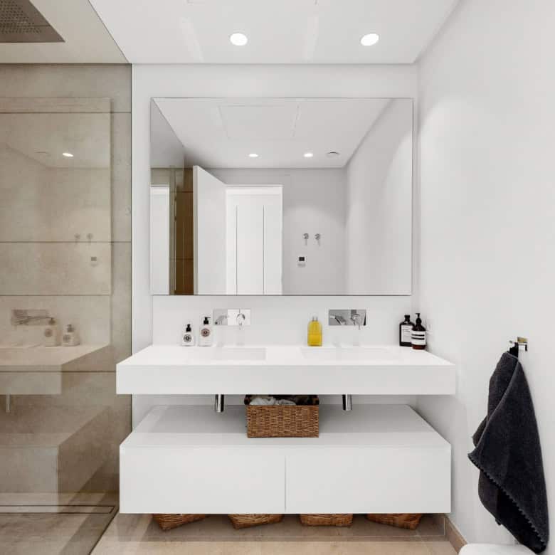 Modern bathroom with sleek white vanity, large mirror, and contemporary fixtures in Marbella duplex.
