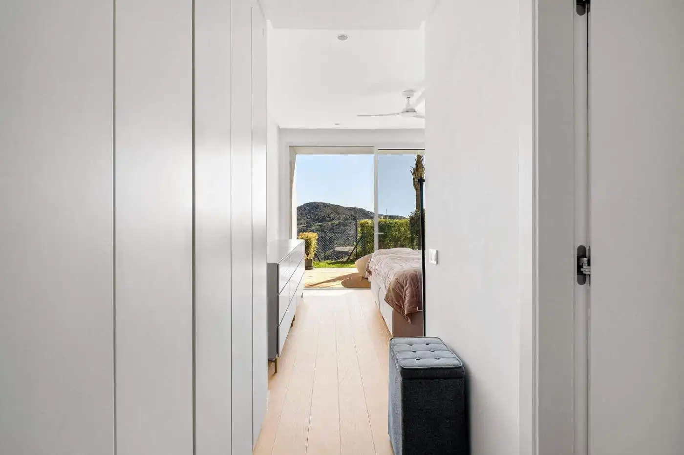 Bright bedroom with sea and mountain vistas in Marbella duplex apartment.
