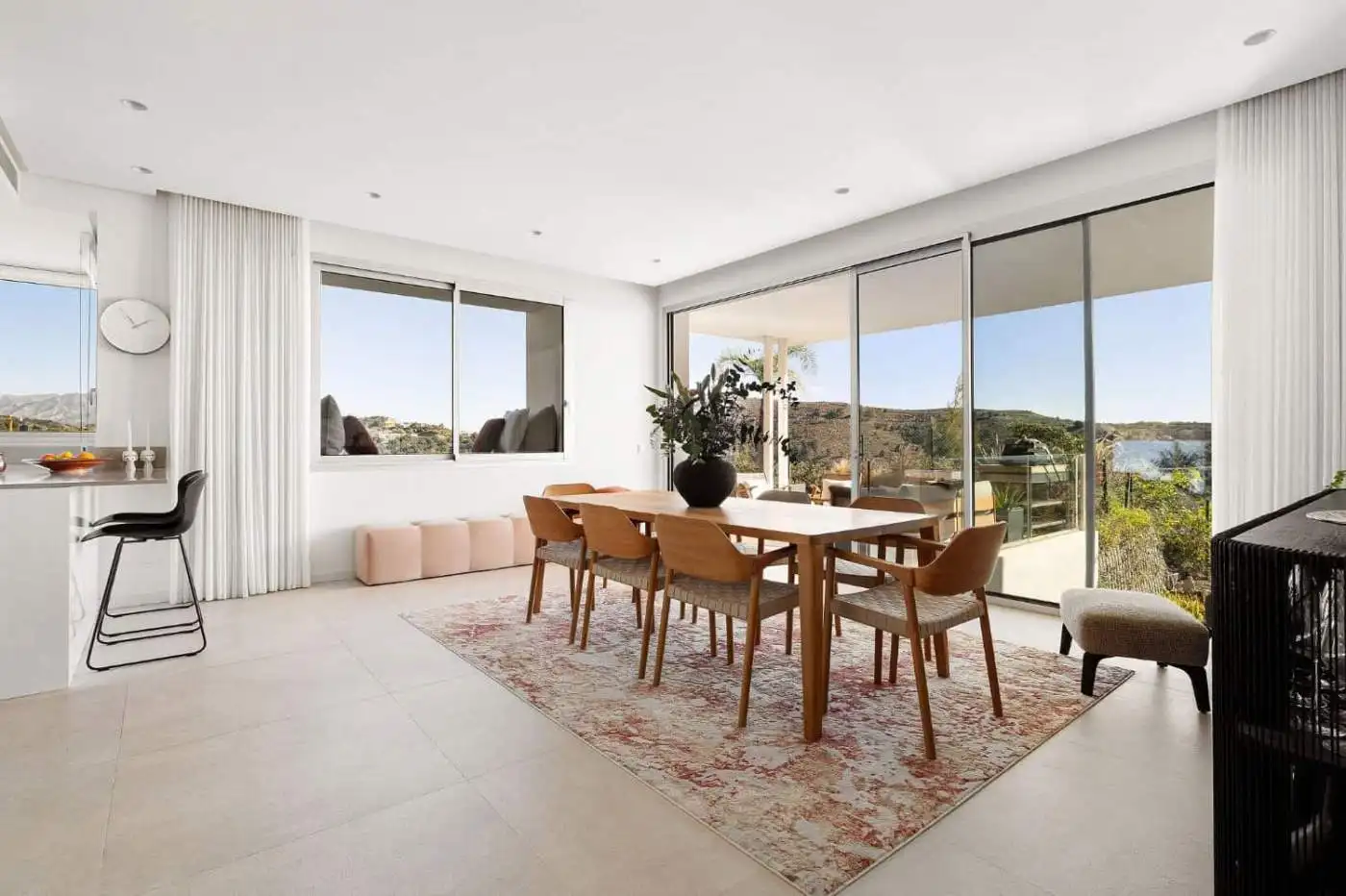 Bright living room with large windows showcasing sea and mountain scenery in Marbella.