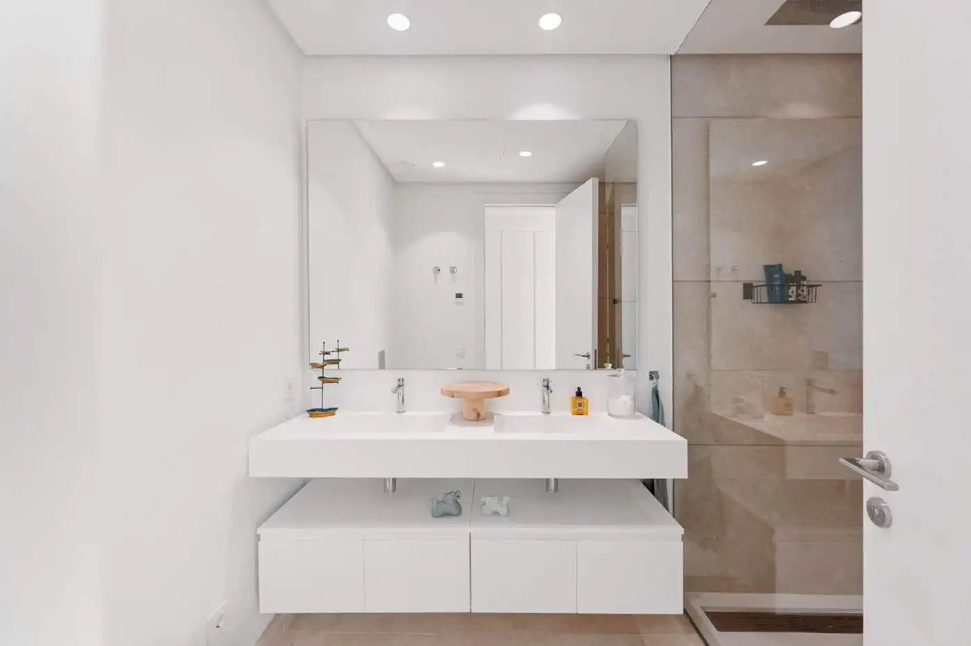 Modern bathroom with white vanity and glass shower in Marbella apartment with sea and mountain views.