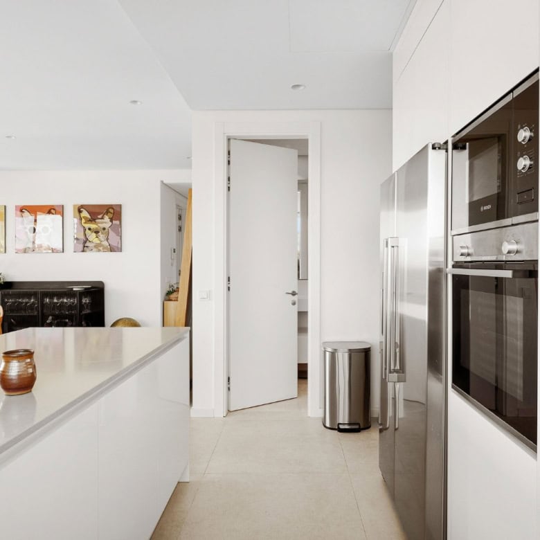 Bright, contemporary kitchen featuring white cabinets, built-in oven, and sea views in Marbella.