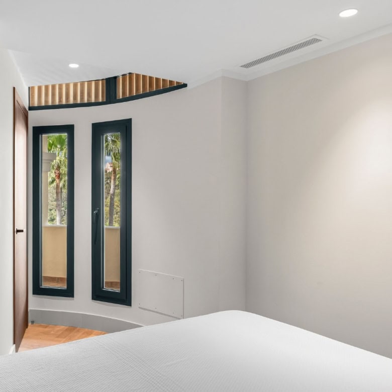 Modern apartment interior with large windows and minimalist design.