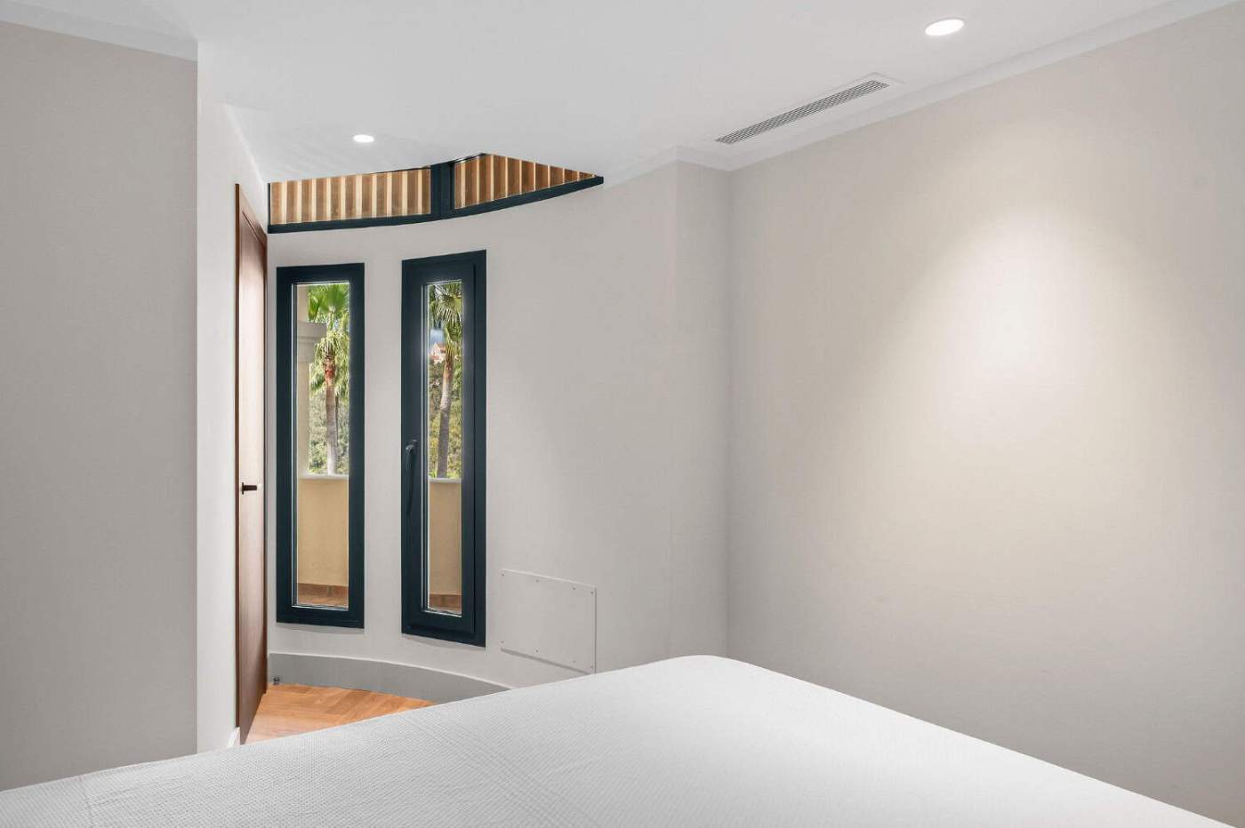 Modern apartment interior with large windows and minimalist design.