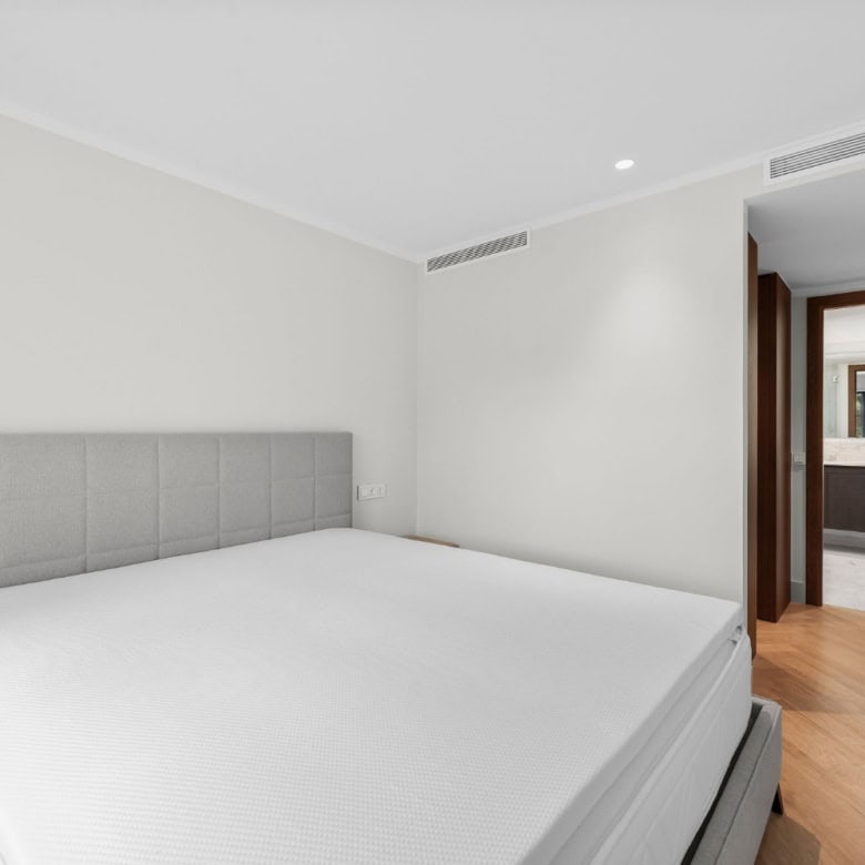 Spacious loft-style apartment bedroom featuring a neutral color palette and contemporary furnishings.
