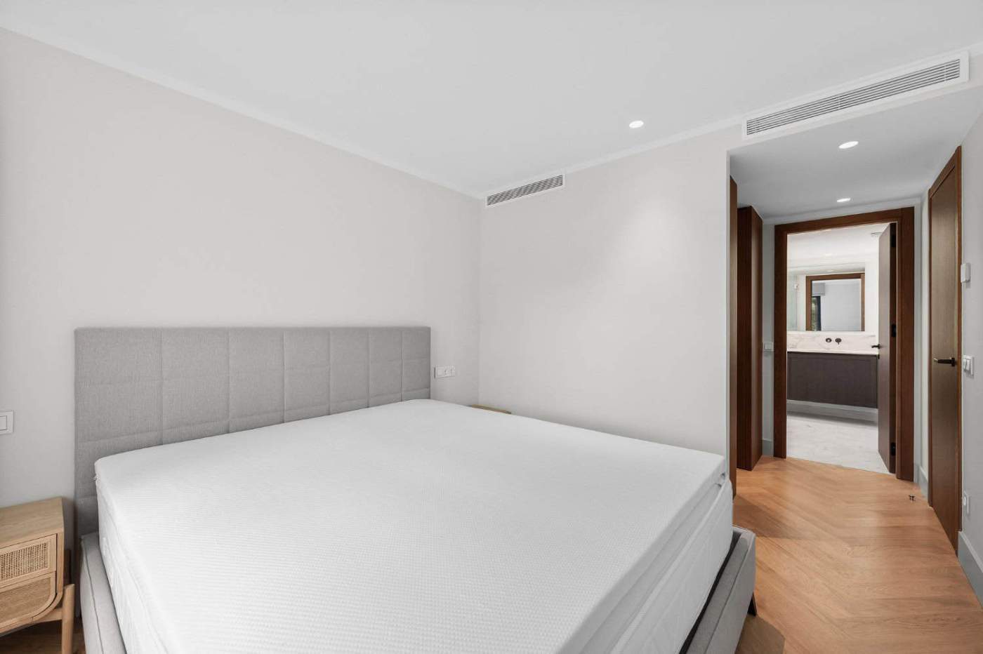 Spacious loft-style apartment bedroom featuring a neutral color palette and contemporary furnishings.