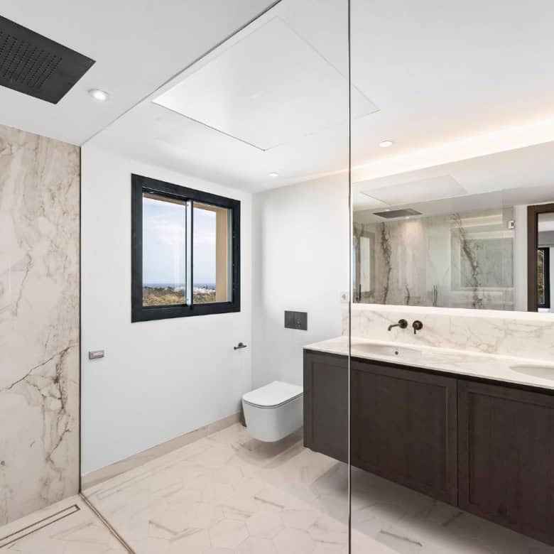 Modern loft-style apartment bathroom with marble accents and scenic views in Nueva Andalucia.
