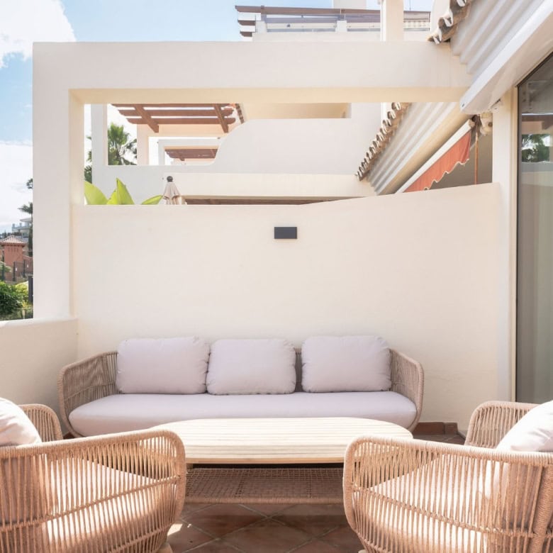 Balcony with stylish wicker furniture and comfortable cushions offering scenic views in Palacetes Le.
