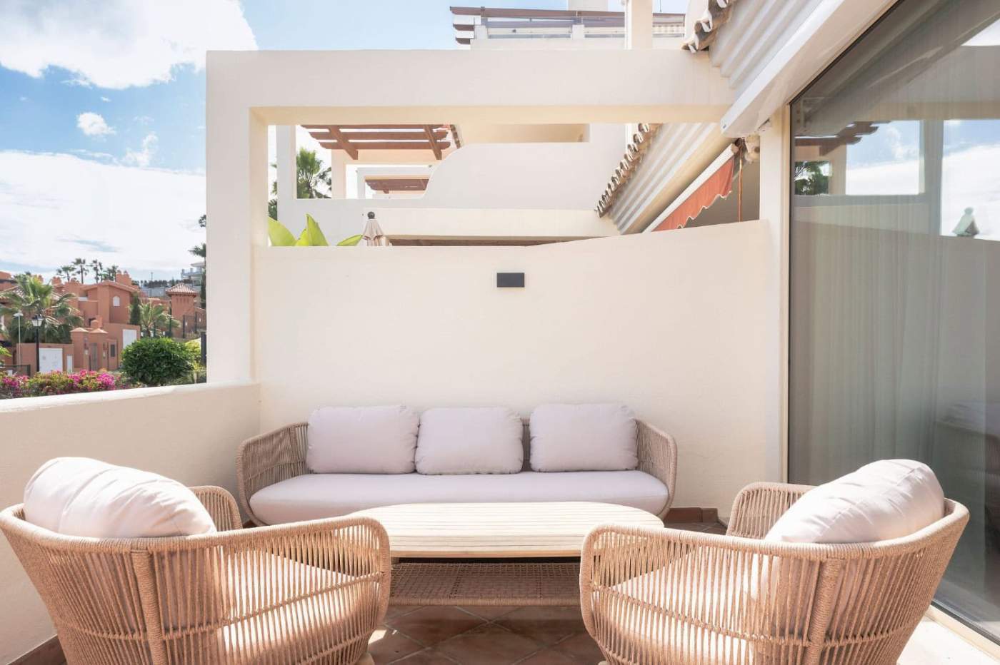 Balcony with stylish wicker furniture and comfortable cushions offering scenic views in Palacetes Le.