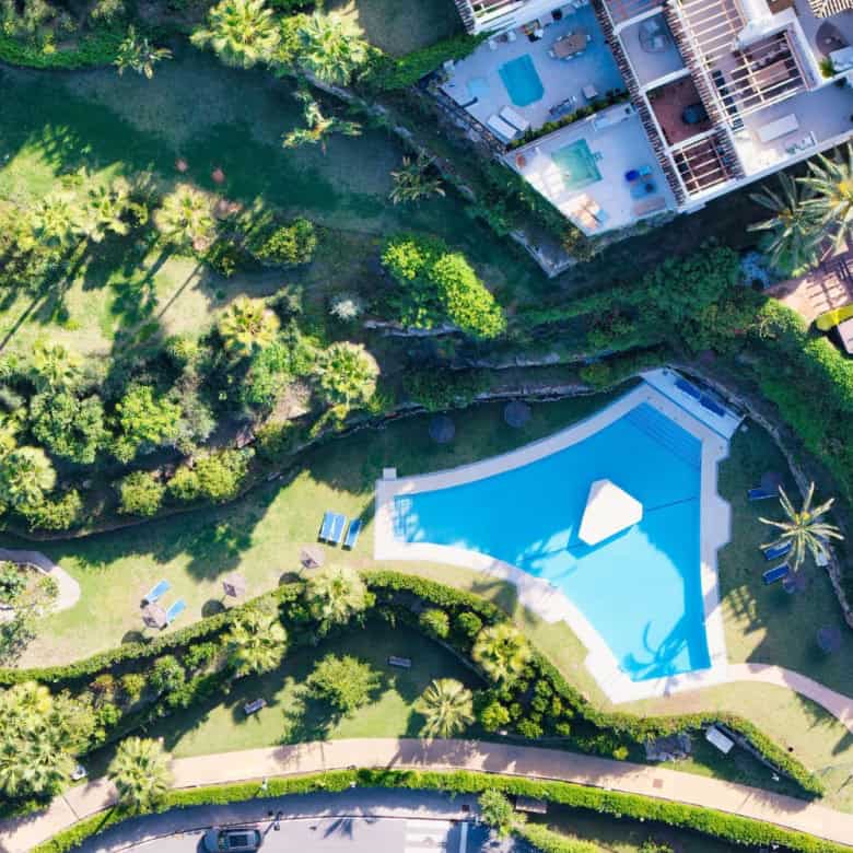 Aerial view of a luxurious loft-style apartment featuring a private pool and lush greenery in Palace.