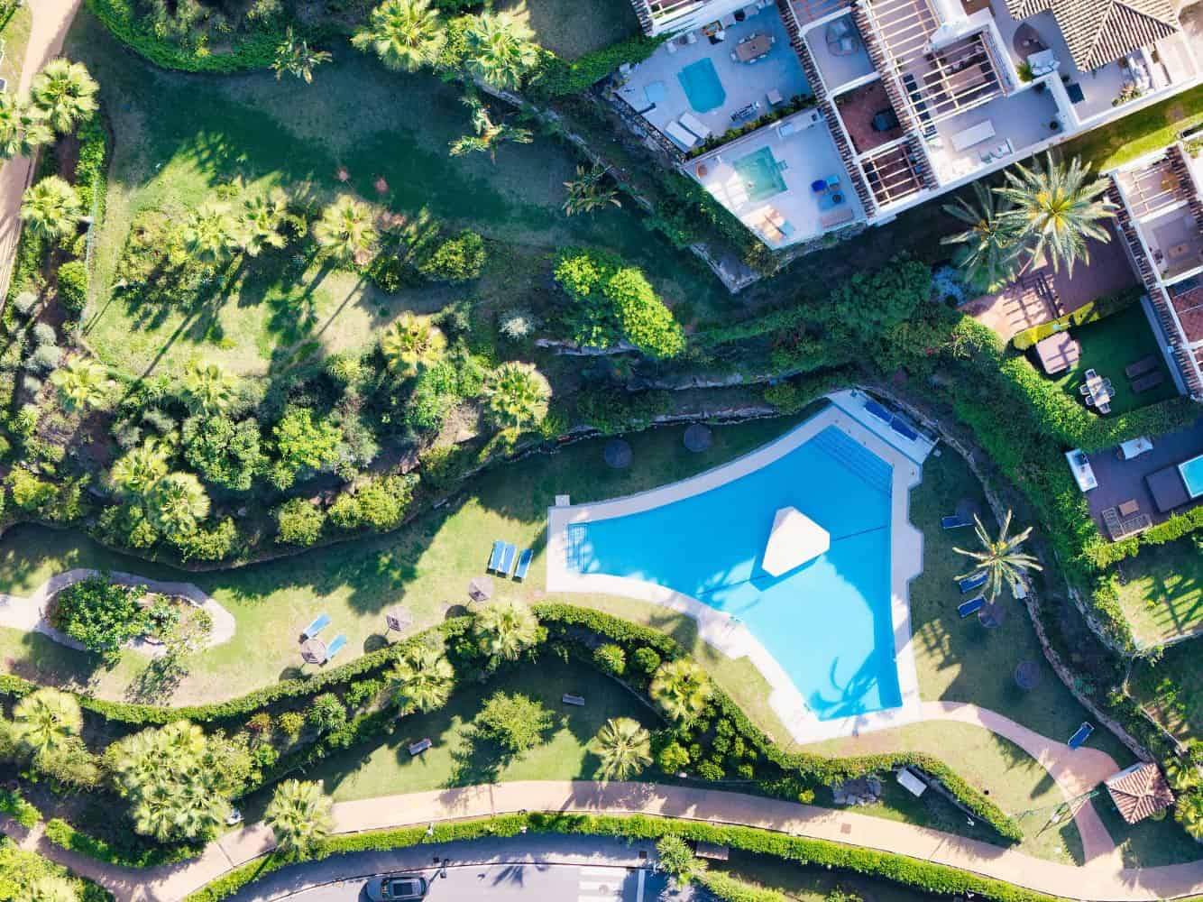 Aerial view of a luxurious loft-style apartment featuring a private pool and lush greenery in Palace.