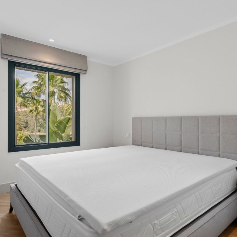 Bedroom with large window overlooking lush greenery in Palacetes Les Belvederes.