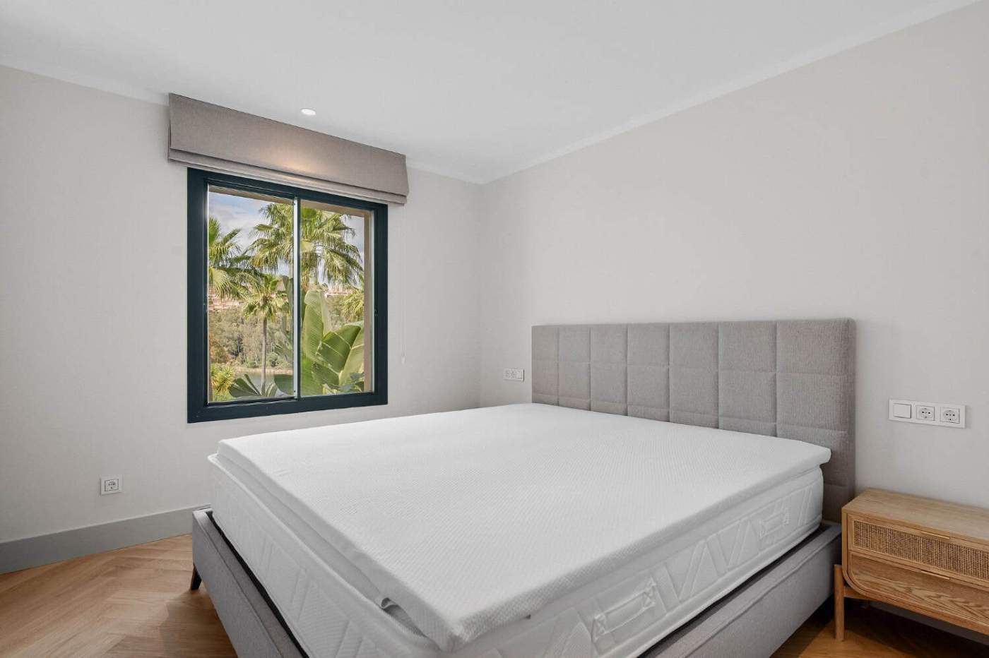 Bedroom with large window overlooking lush greenery in Palacetes Les Belvederes.