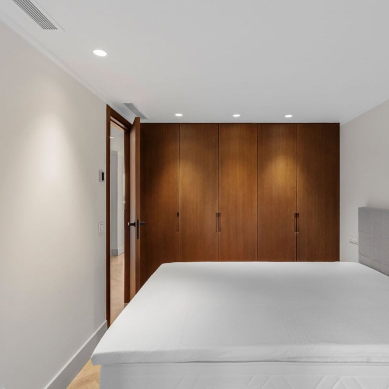 Spacious bedroom featuring a large bed, neutral tones, and ample storage in Palacetes Les Belvederes.