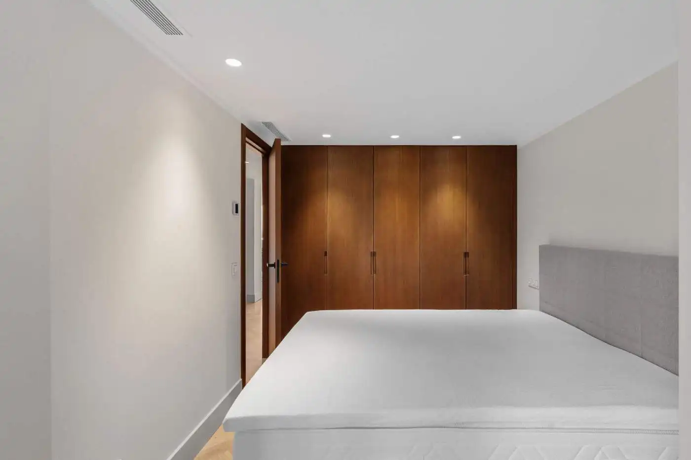 Spacious bedroom featuring a large bed, neutral tones, and ample storage in Palacetes Les Belvederes.