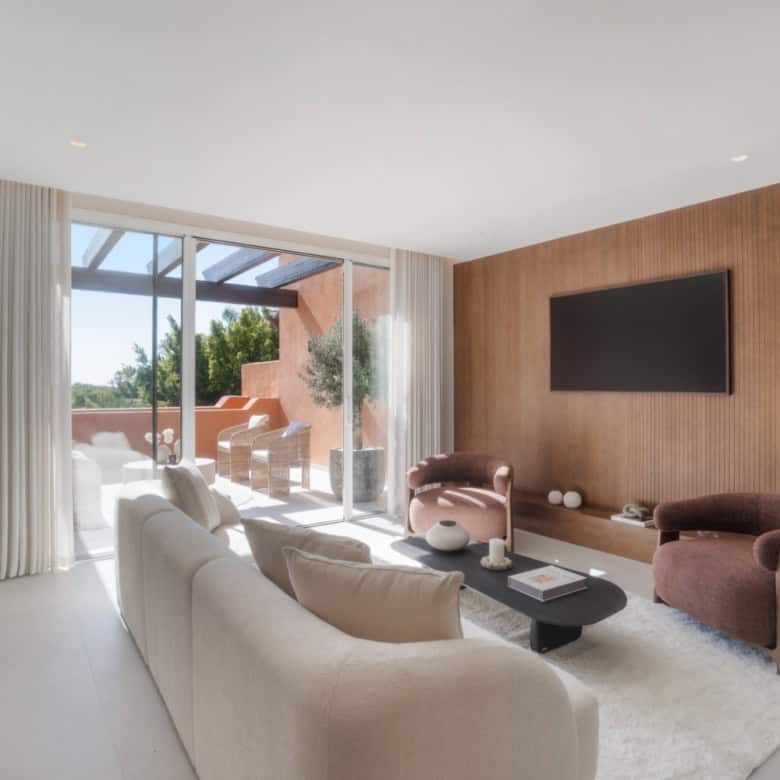 Luxury duplex penthouse living room with modern decor and spacious balcony in Marbella.