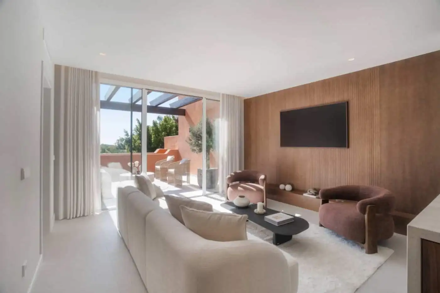 Luxury duplex penthouse living room with modern decor and spacious balcony in Marbella.