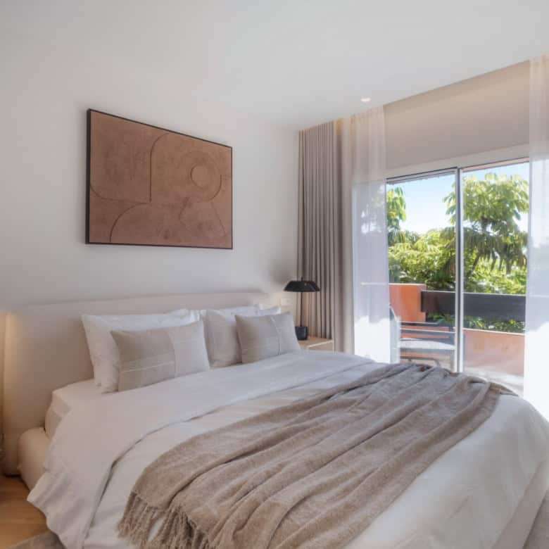 Luxurious renovated duplex penthouse bedroom in Alminar de Marbella with balcony and scenic views.