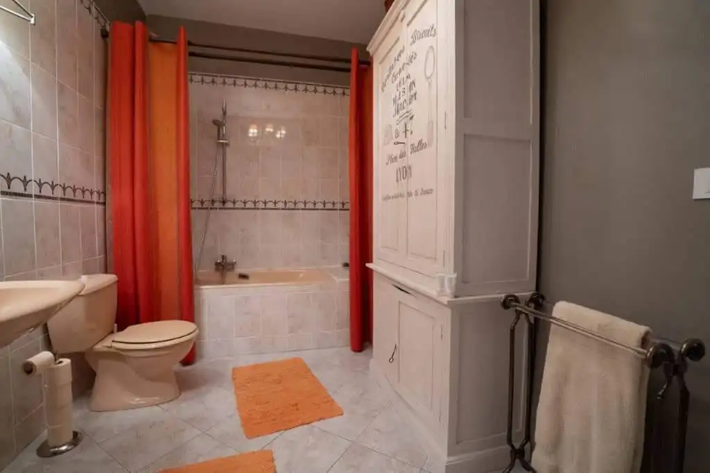 Bright bathroom with bathtub, shower, and modern fixtures in Chateaudun, France. Perfect for comfort.