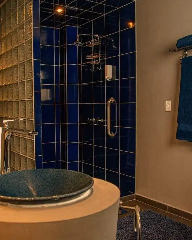 Bathroom with blue tiled shower in Ecuador property.