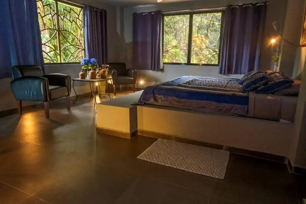 Spacious bedroom featuring large windows overlooking a flowing river in Llurimagua, Ecuador. Perfect.
