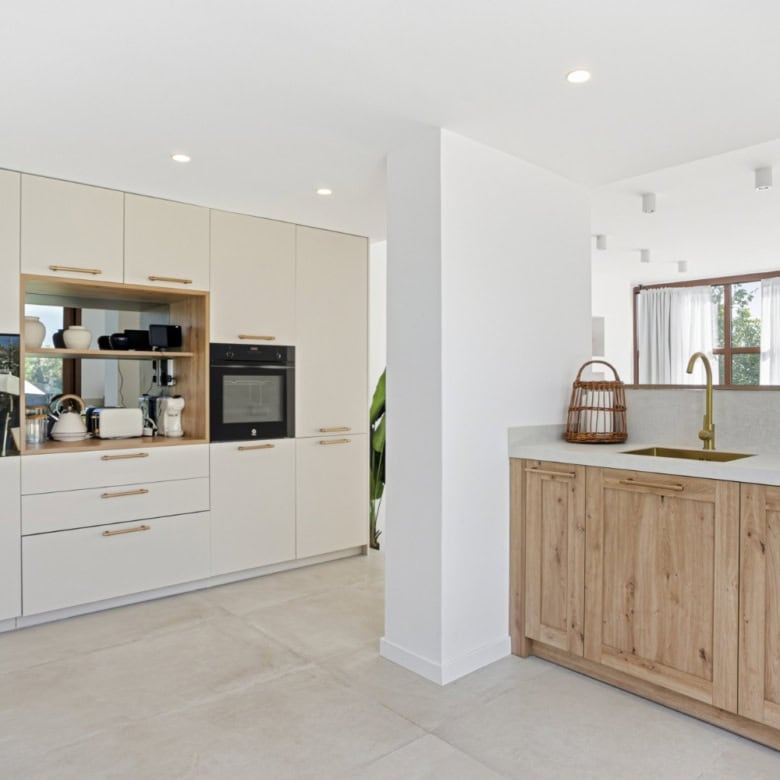 Bright, contemporary kitchen with white cabinets and natural wood details in Cancelada, Estepona.