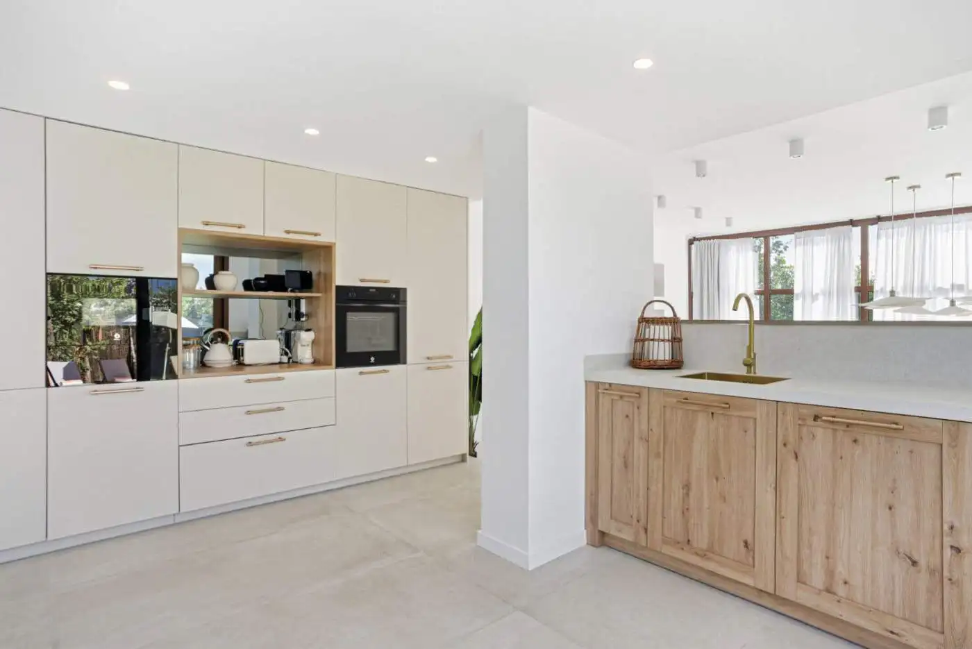 Bright, contemporary kitchen with white cabinets and natural wood details in Cancelada, Estepona.