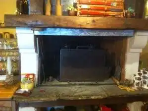 Cozy fireplace in a luxurious estate with wooden accents and decorative items, perfect for relaxing.