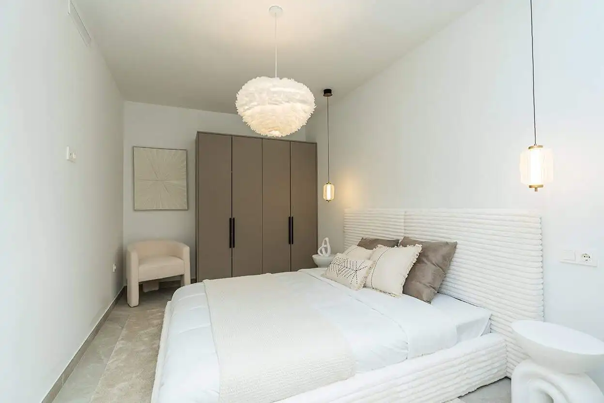 Spacious bedroom in a fully refurbished Marbella Golf Valley townhouse with contemporary decor.