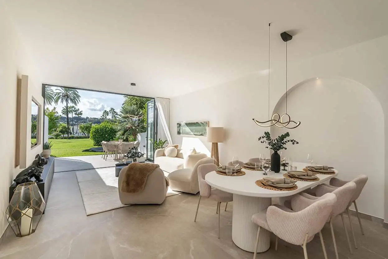 Spacious living area in Marbella Golf Valley townhouse with stylish decor and large glass doors open.