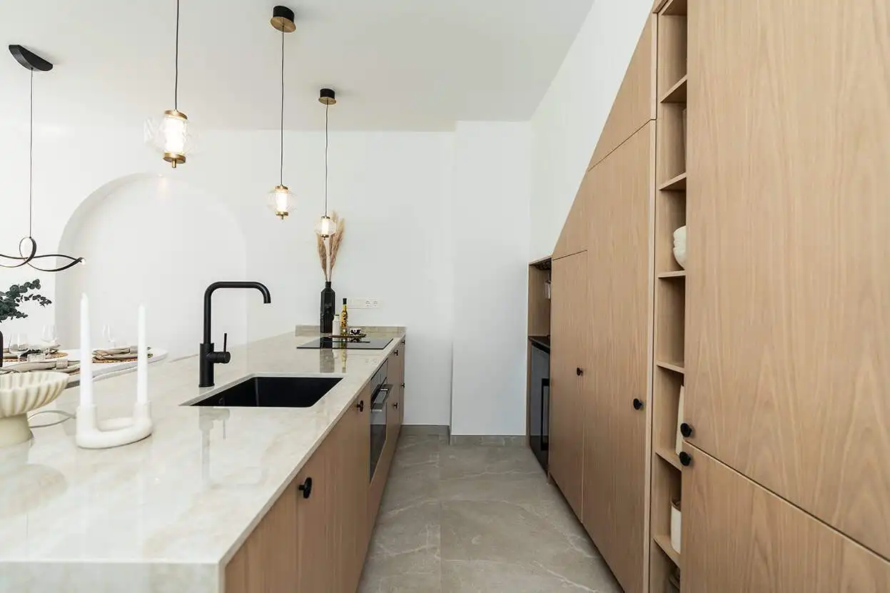 Contemporary kitchen featuring wooden cabinetry, a sleek black sink, and stylish pendant lights, per.