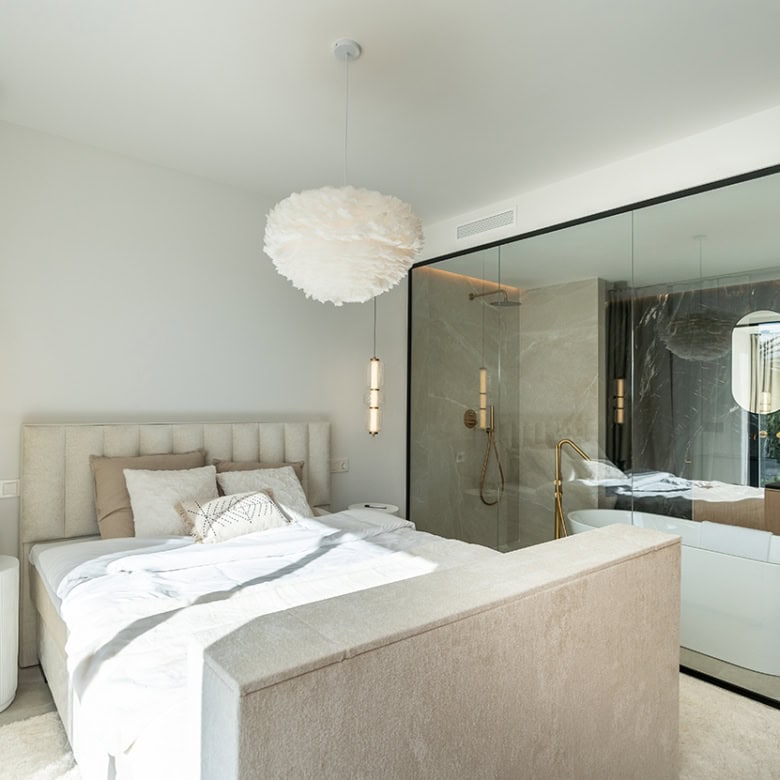 Spacious bedroom in a fully refurbished Marbella townhouse with elegant decor and natural light.