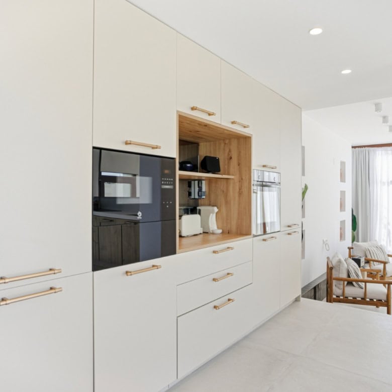 Modern white kitchen with wooden accents in a stylish townhouse.