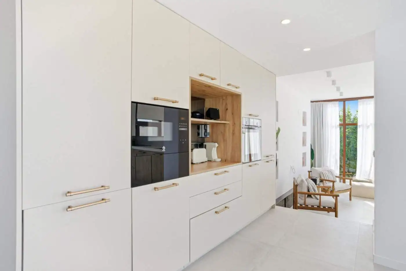Modern white kitchen with wooden accents in a stylish townhouse.