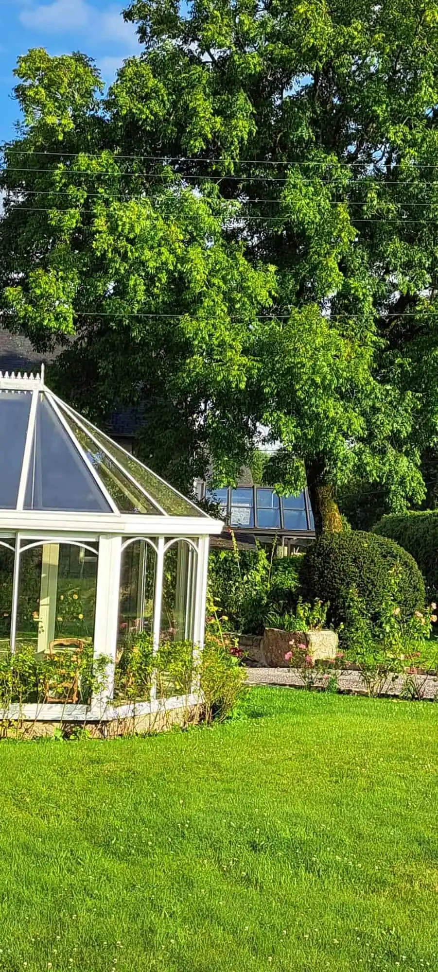 Elegant estate with lush greenery and a glass conservatory in Brittany.