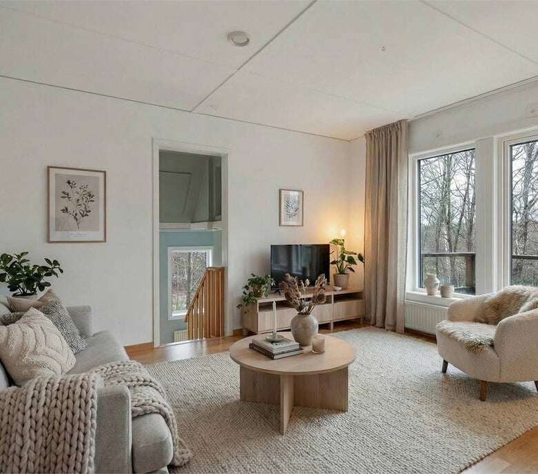 Spacious living room in a beautiful 3-bedroom house in Ljungskile, featuring large windows and cozy.