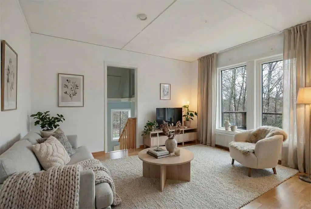 Spacious living room in a beautiful 3-bedroom house in Ljungskile, featuring large windows and cozy.