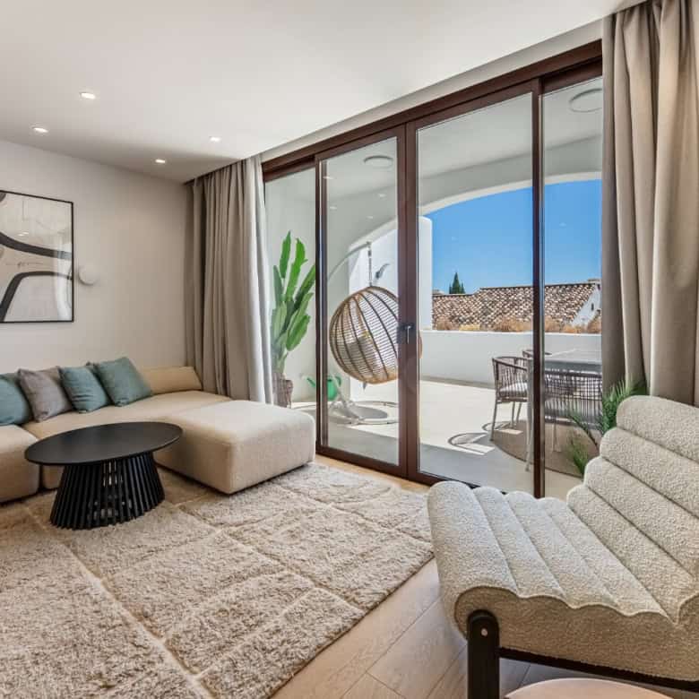 Spacious living room featuring large glass doors opening to a balcony with scenic views in Los Arque.