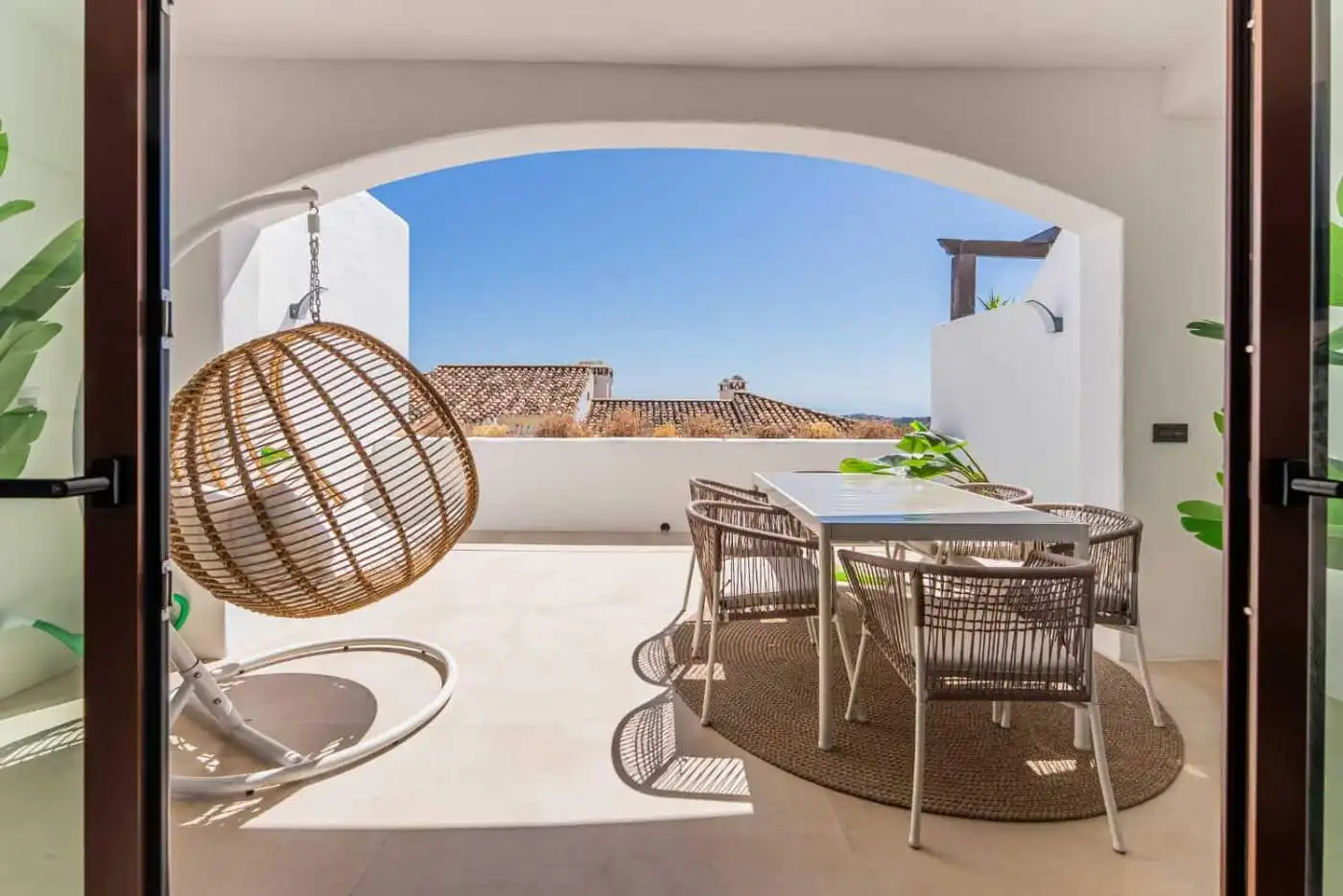 Balcony with sea view, outdoor dining, and hanging chair in Los Arqueros Benahavis.